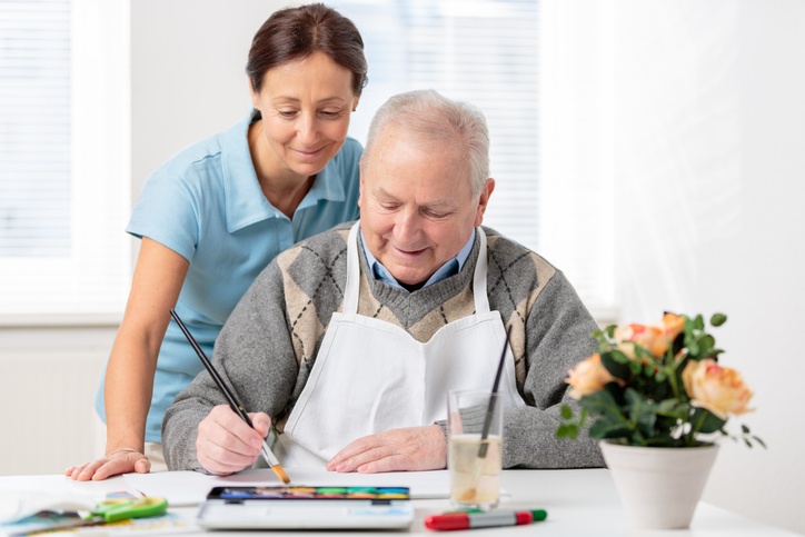 Senior man painting with water colors at Alpine Skilled Nursing & Rehabilitation nursing home in Ruston, LA .